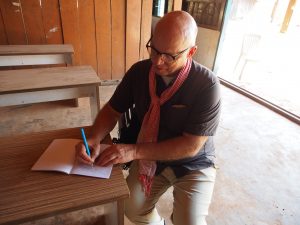 Dana Bourgerie writing at a table